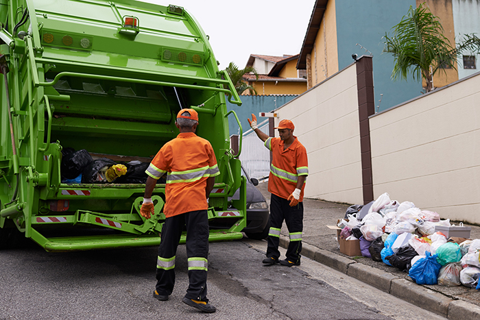 Garbage collectors working with a garbage truck in a city 