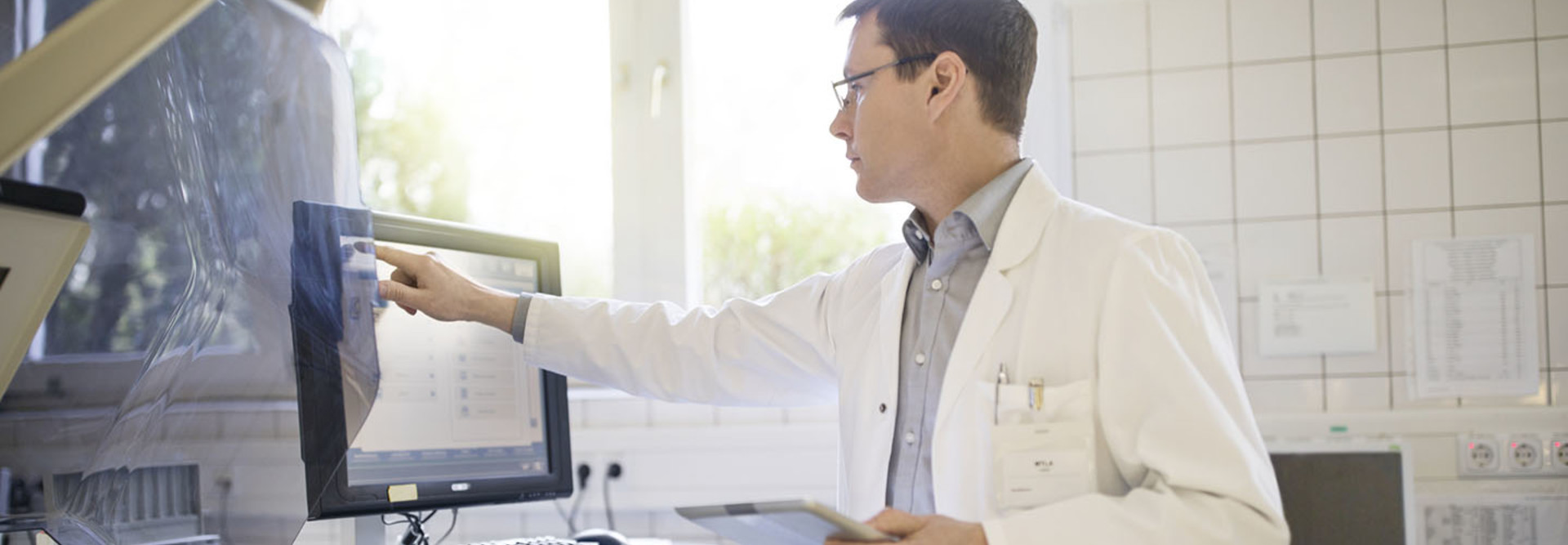 Male doctor using computer with tablet