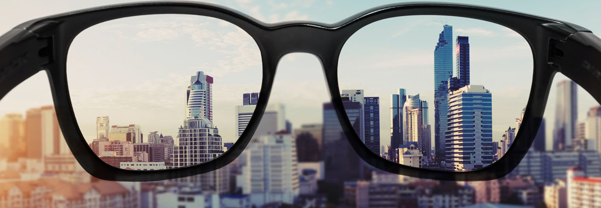 Eye glasses looking to city view, focused on glasses lens