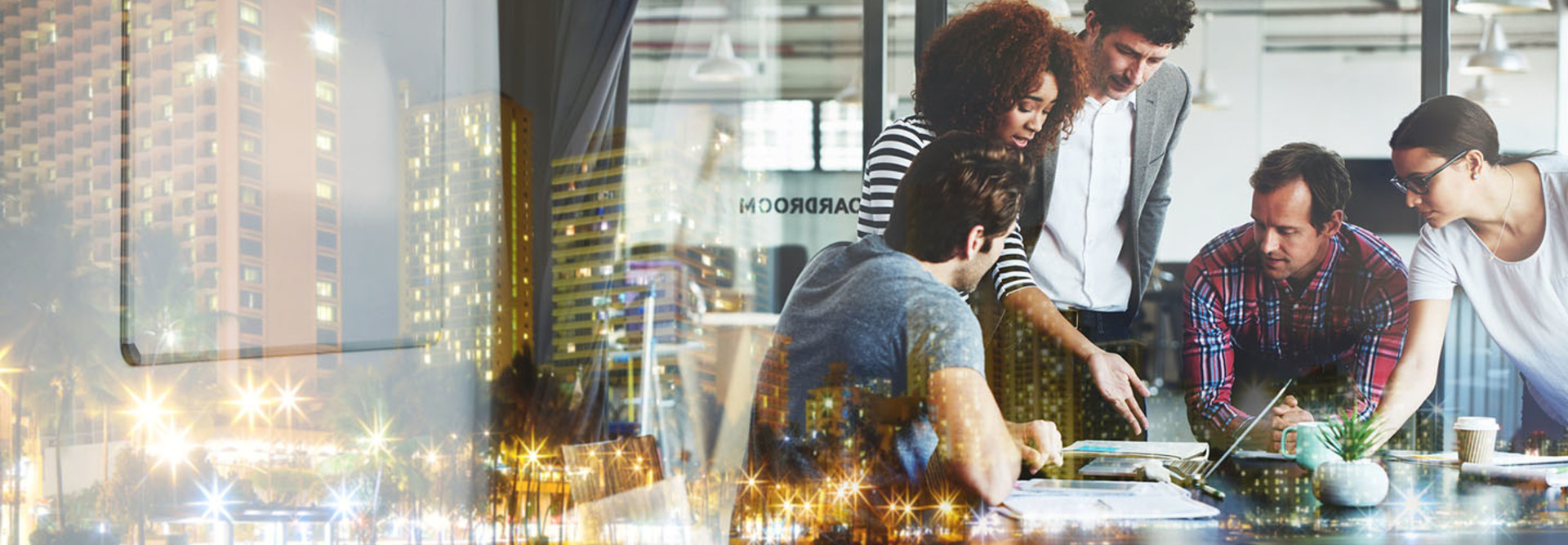 Multiple exposure shot of a business meeting superimposed over a city