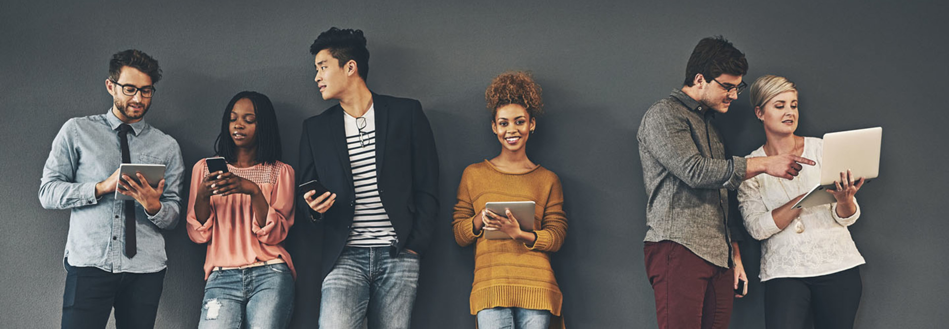 Studio shot of a diverse group of creative employees working on various devices