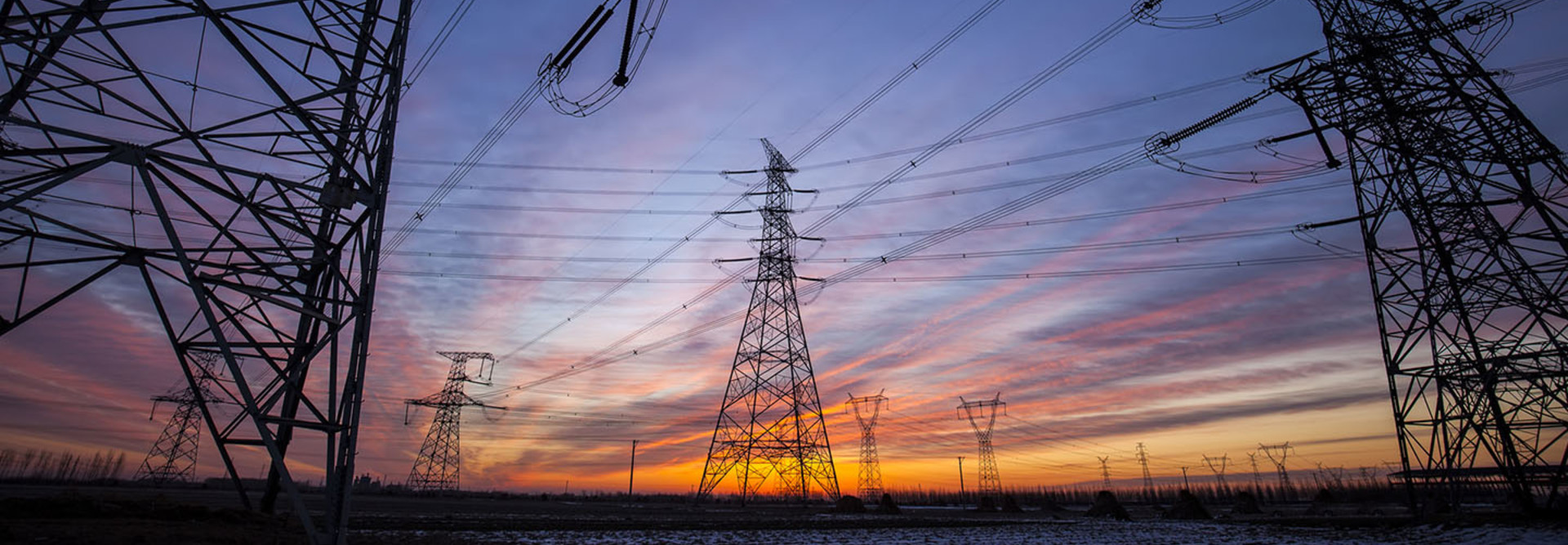 The silhouette of the evening electricity transmission pylon