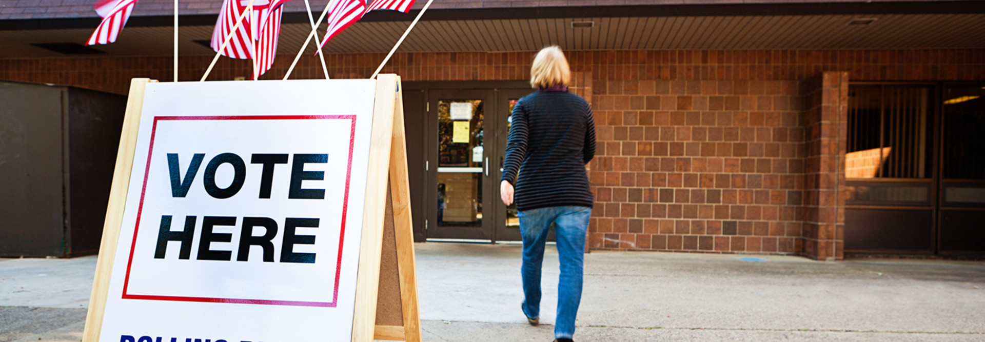 Woman walking into a polling place to vote