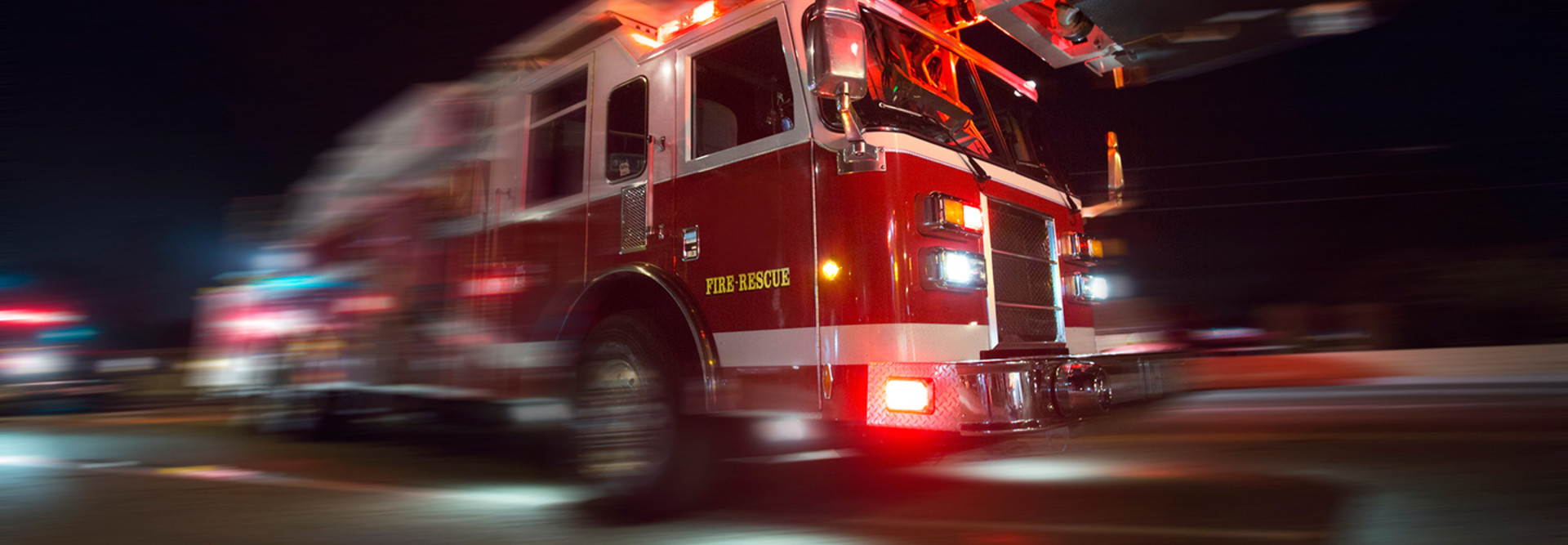 Fire truck speeding down a street with lights flashing 