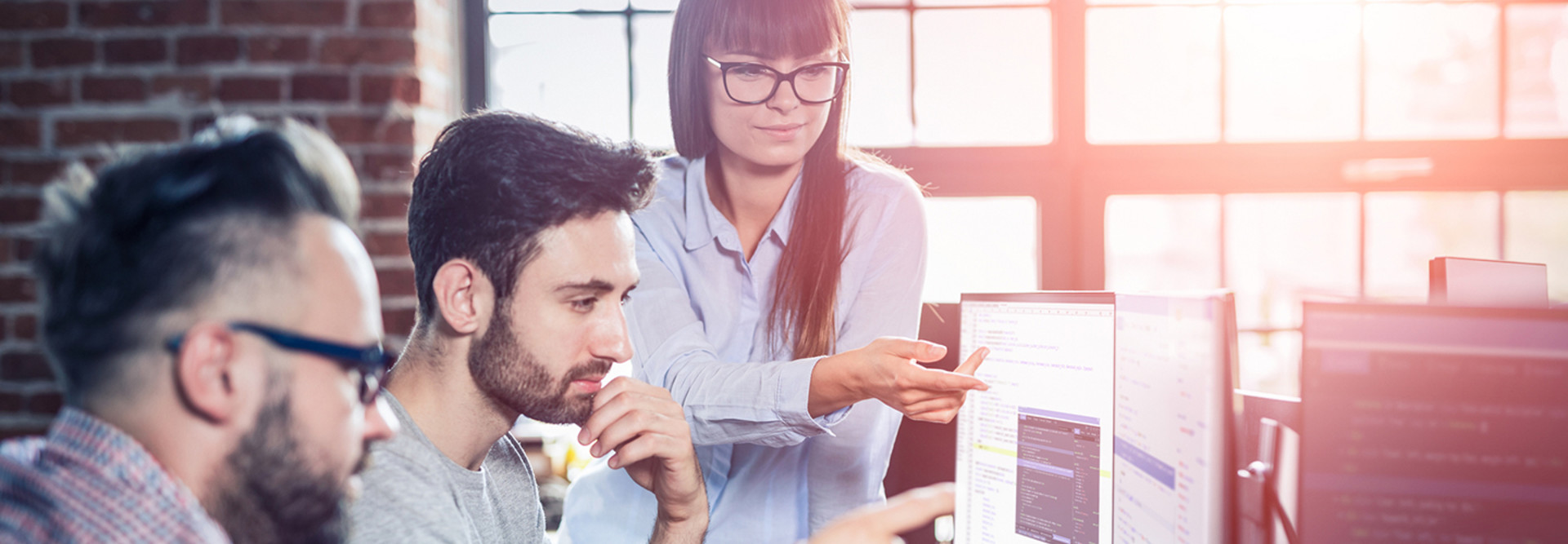 Local government cybersecurity team, a woman and two men at computers