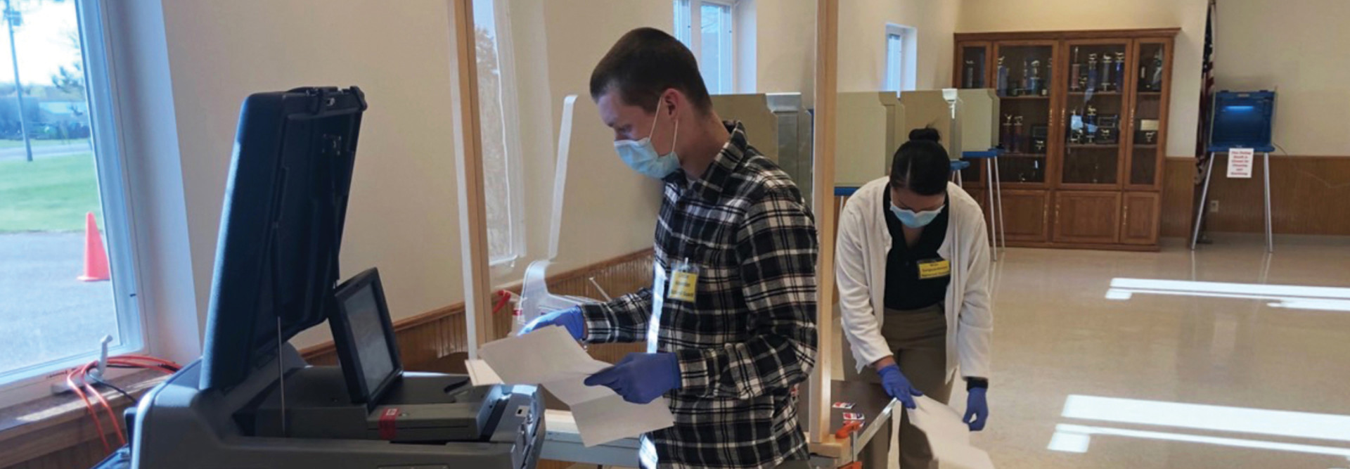 Spc. Lincoln Meverden and Pfc. Napatsawan Sanguanboon, both of the 132nd Brigade Support Battalion, process ballots May 12 in Maine, Wisconsin.