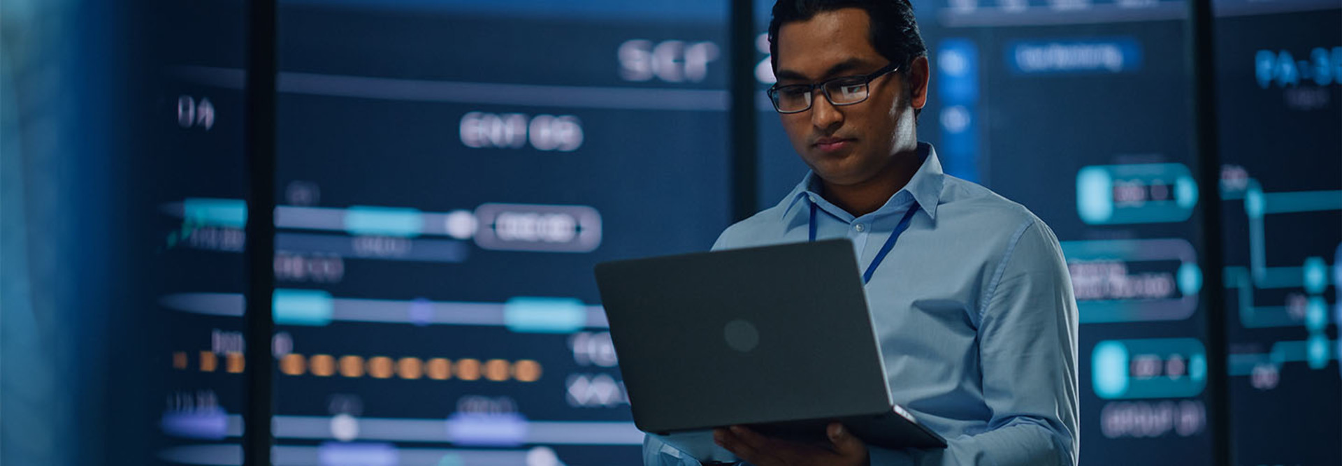 Professional looking at data holding laptop