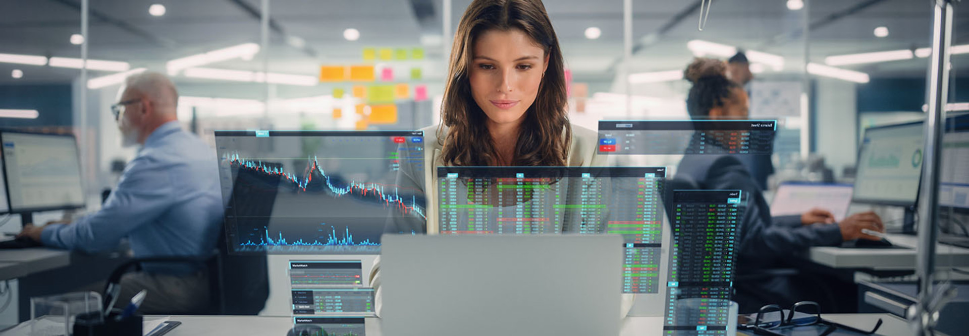 Young woman Using Laptop Computer in Modern Office with Colleagues. VFX of opened charts.