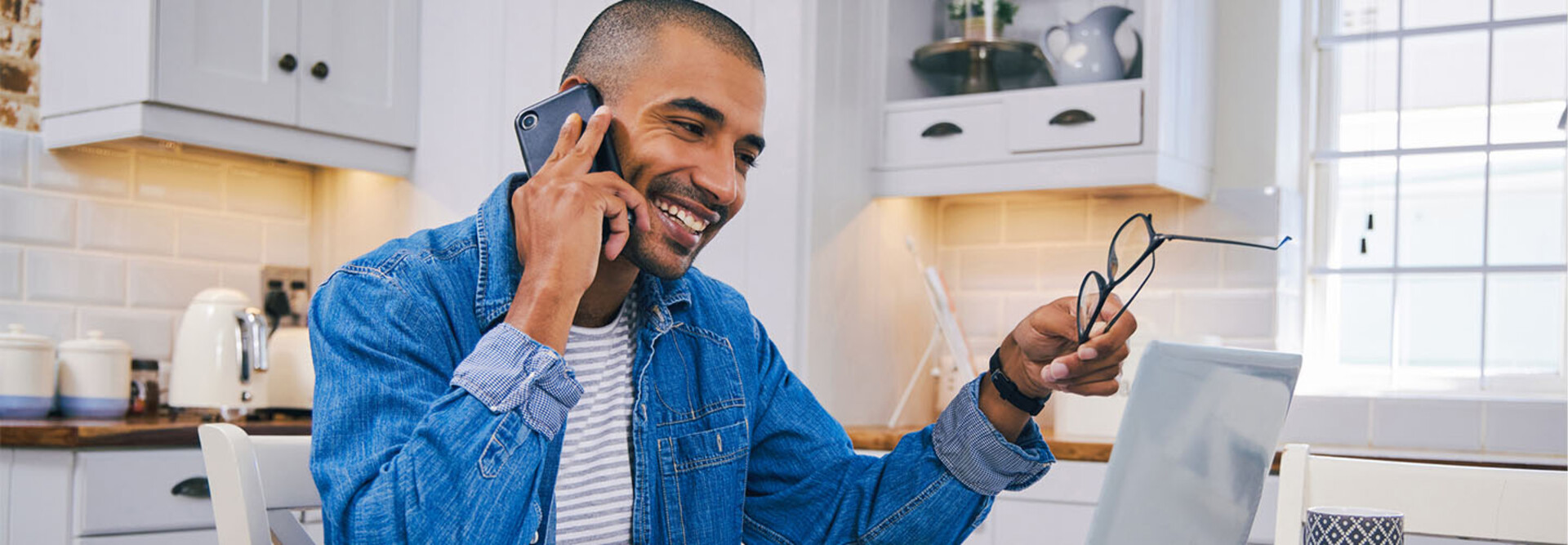 Person talking on the phone and using a laptop