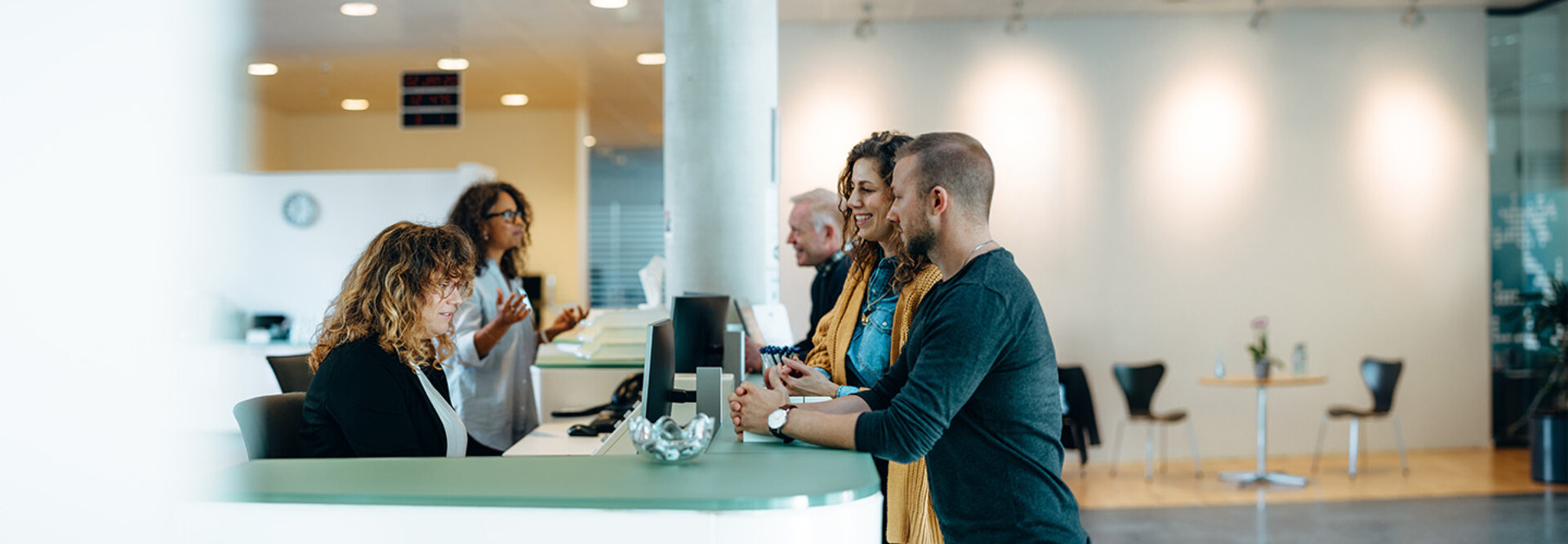 People speaking to receptionist
