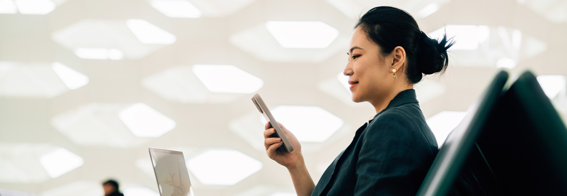 Woman on laptop with phone