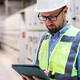 Electrical engineer in control room using digital tablet