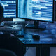 Man examining blurred code in a dark room