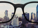 Eye glasses looking to city view, focused on glasses lens