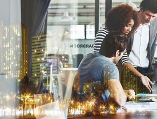 Multiple exposure shot of a business meeting superimposed over a city