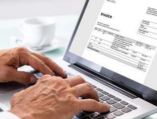 Man looking at an invoice on a laptop