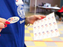 Woman handing out an I voted sticker on Election Day 