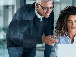 Shot of two professionals working on a laptop in an office.