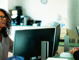 People speaking at a front desk