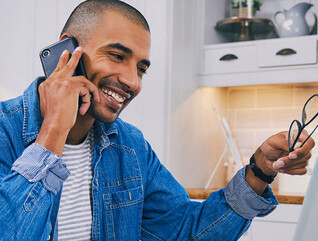 Person talking on the phone and using a laptop