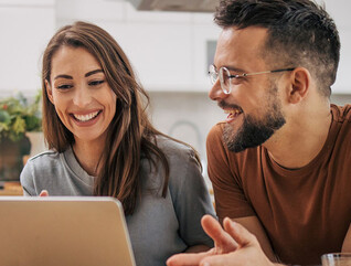 A couple using a computer at home