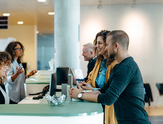 People speaking to receptionist
