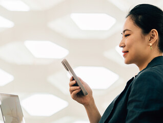 Woman on laptop with phone