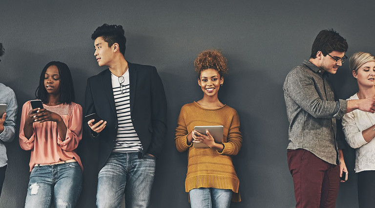 Studio shot of a diverse group of creative employees working on various devices