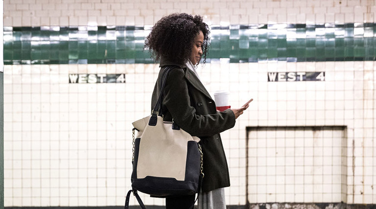 Young woman waiting for the subway train in New York, USA.