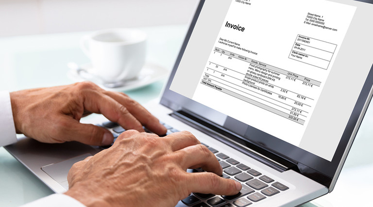 Man looking at an invoice on a laptop