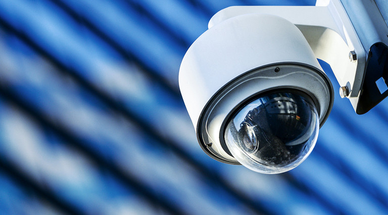 Surveillance camera on a lamp post in a city