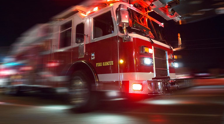 Fire truck speeding down a street with lights flashing 