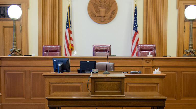Empty courtroom with three judges' chairs 
