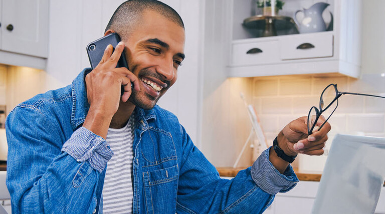 Person talking on the phone and using a laptop