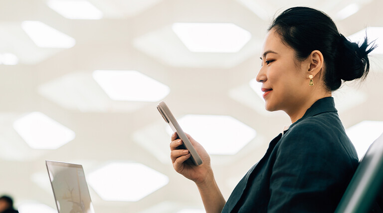Woman on laptop with phone