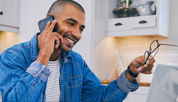 Person talking on the phone and using a laptop