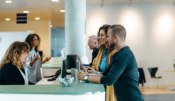 People speaking to receptionist