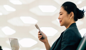 Woman on laptop with phone