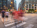 People walking across a cross-walk in Chicago at dusk 