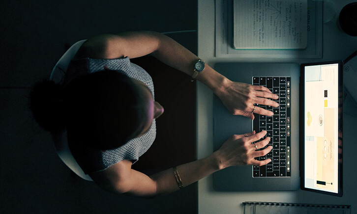 Employee using computer in a dark room