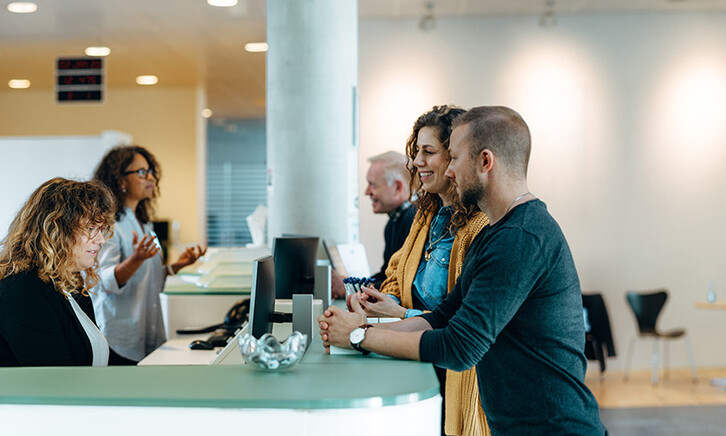 People speaking to receptionist
