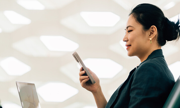 Woman on laptop with phone