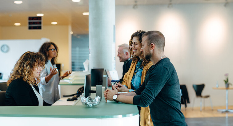 People speaking to receptionist