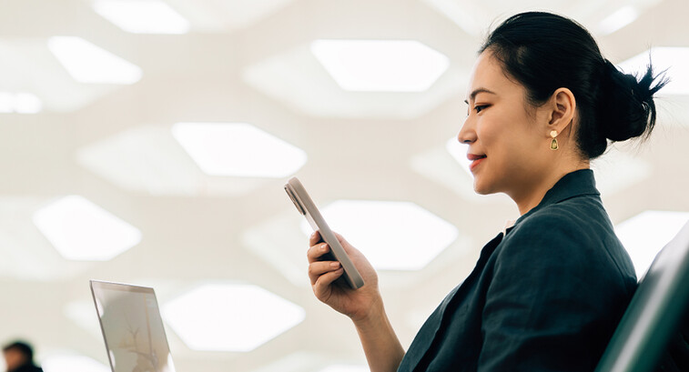 Woman on laptop with phone
