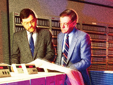 Two men working on mainframe computers in the 1980s 