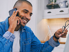 Person talking on the phone and using a laptop