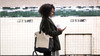 Young woman waiting for the subway train in New York, USA.