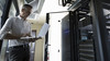 Male Caucasian IT technician using laptop in server room