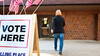 Woman walking into a polling place to vote