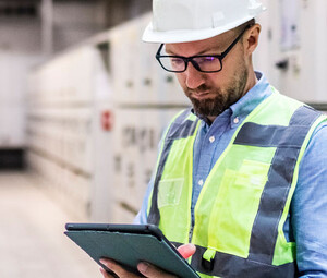 Electrical engineer in control room using digital tablet